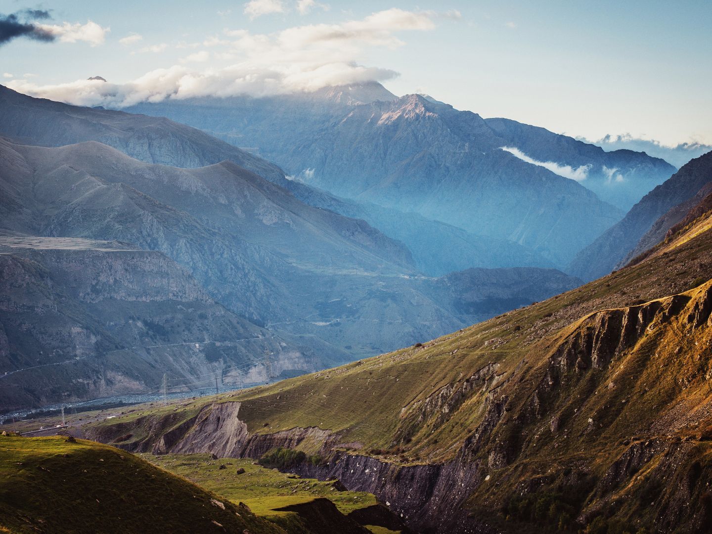 Breathtaking landscape of Mount Kazbek and the Caucasus ranges under a cloudy sky.